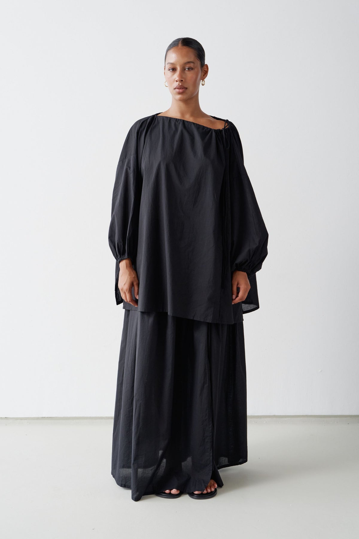 Model wearing the Joss blouse over the Maya maxi skirt, both in Black