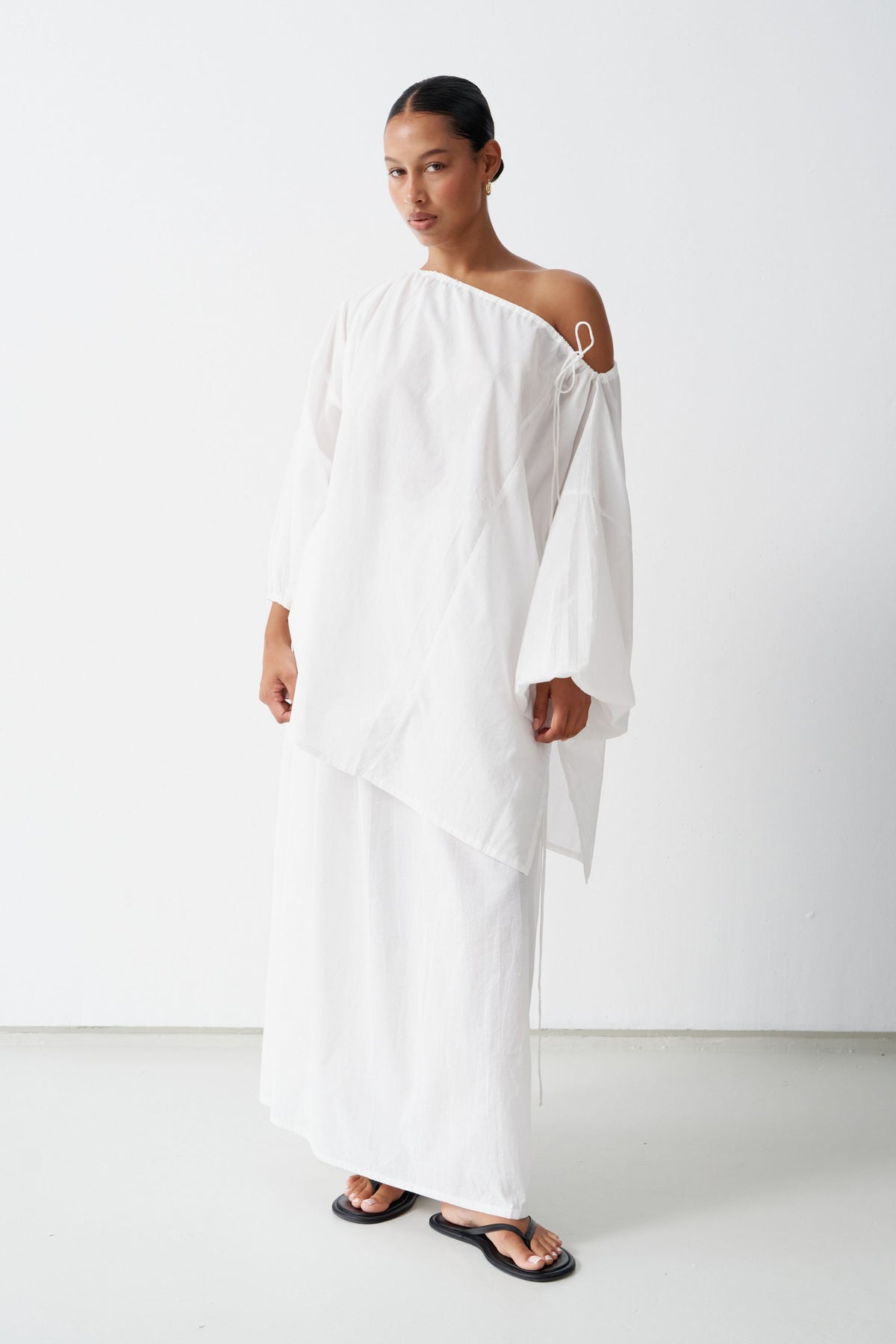 Front view of the Joss blouse and Maya skirt in White, showing the neckline tie, balloon sleeves, side split and waist